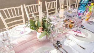 Beautifully arranged dining table for an elegant occasion with floral centerpiece and candles.